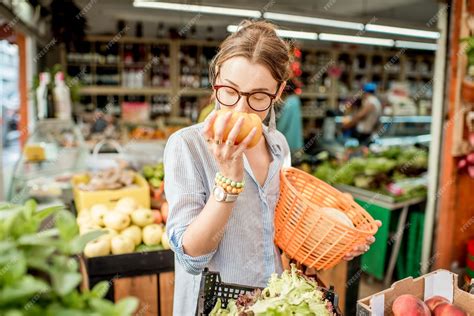 Young Woman Choosing A Fresh Mint Standing With Basket At The Food Market In France Premium Photo